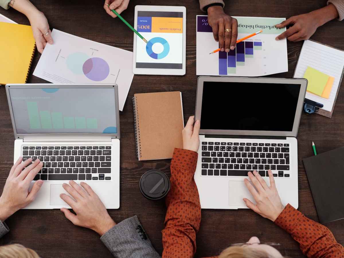 a group of people with graphs and pie charts on table