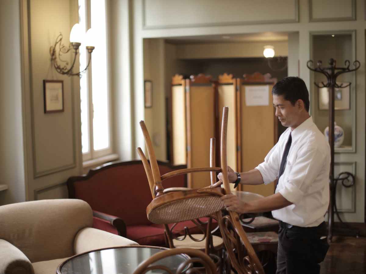 male employee preparing tables in restaurant