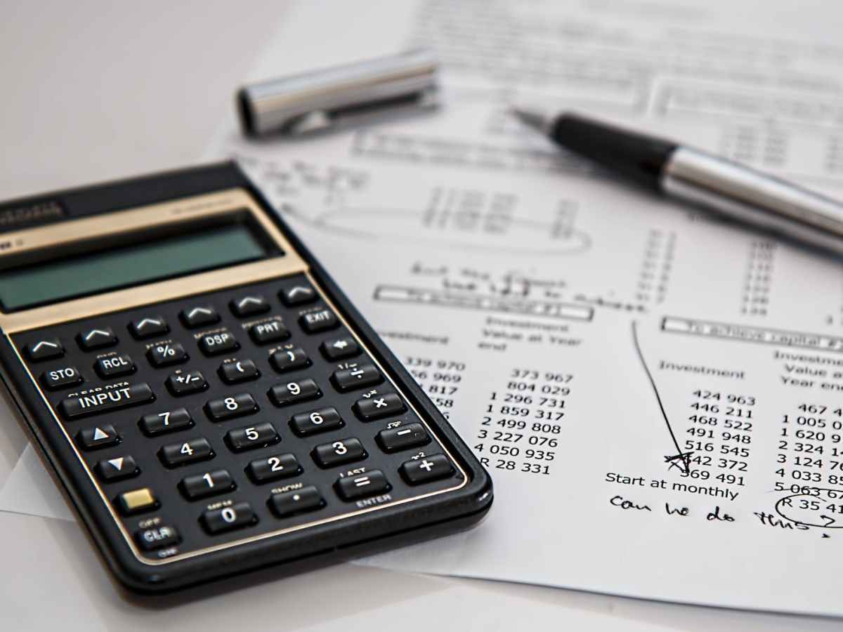 black calculator near ballpoint pen on white printed paper