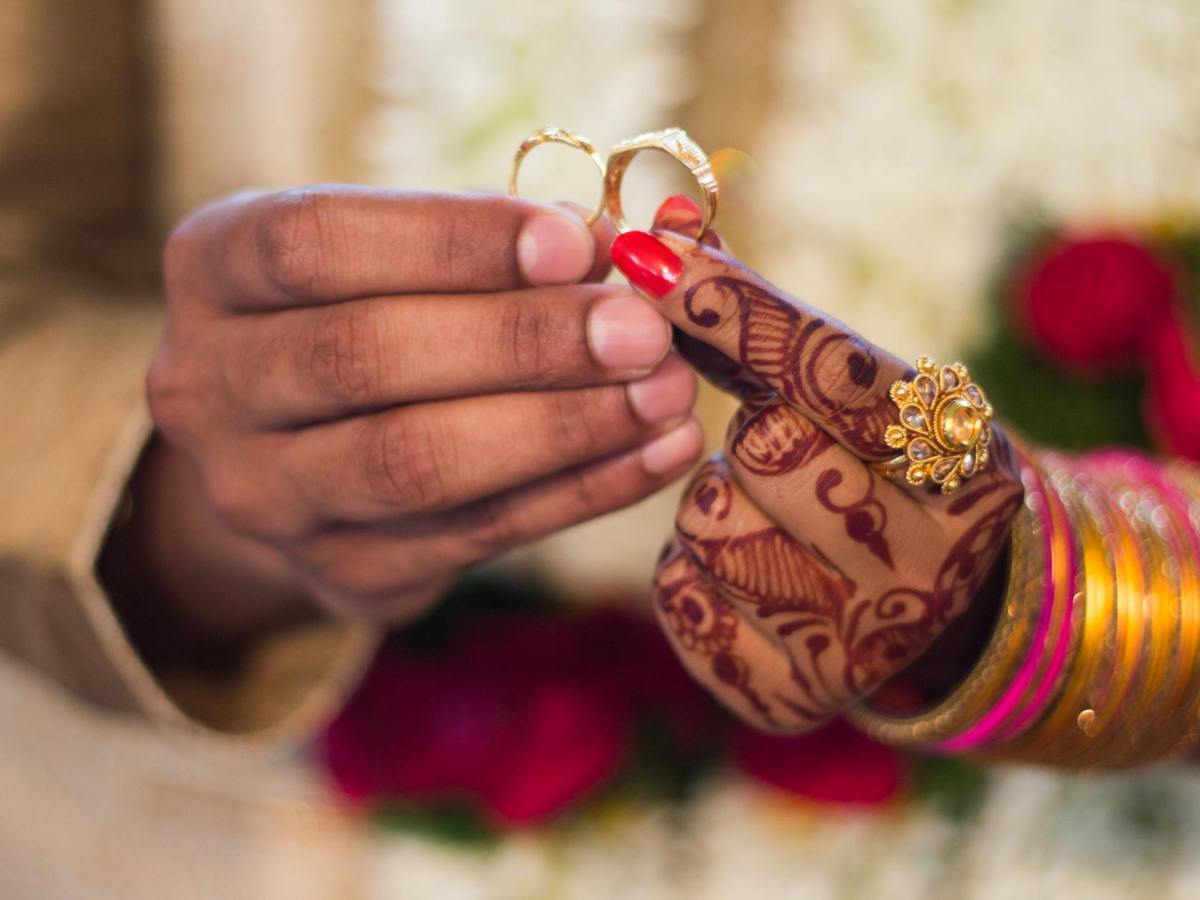 man and woman holding wedding rings
