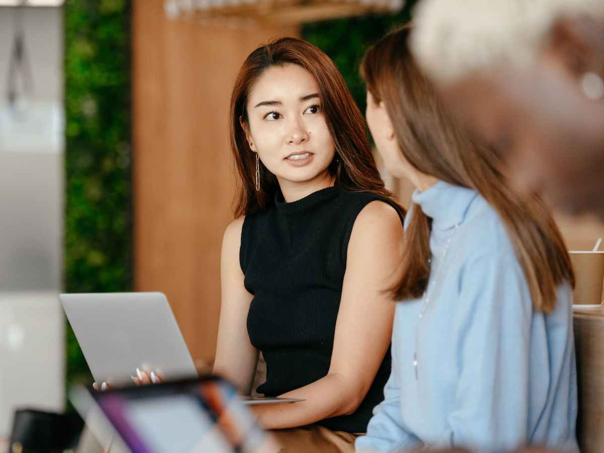 asian woman discussing business plan with diverse colleagues