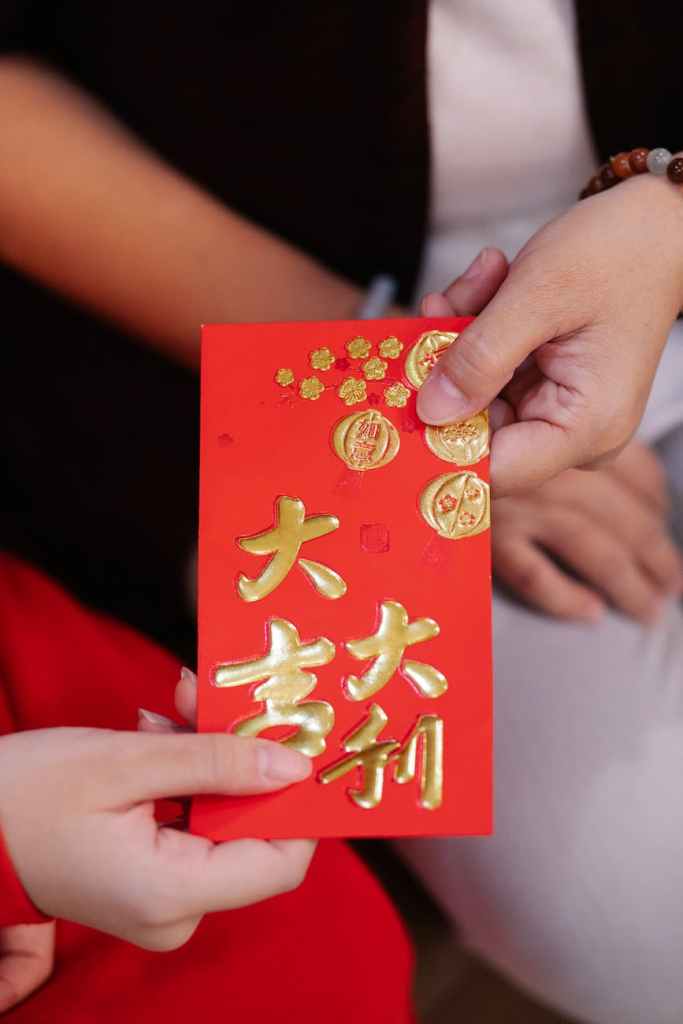 crop woman passing red envelope to relative during festive event