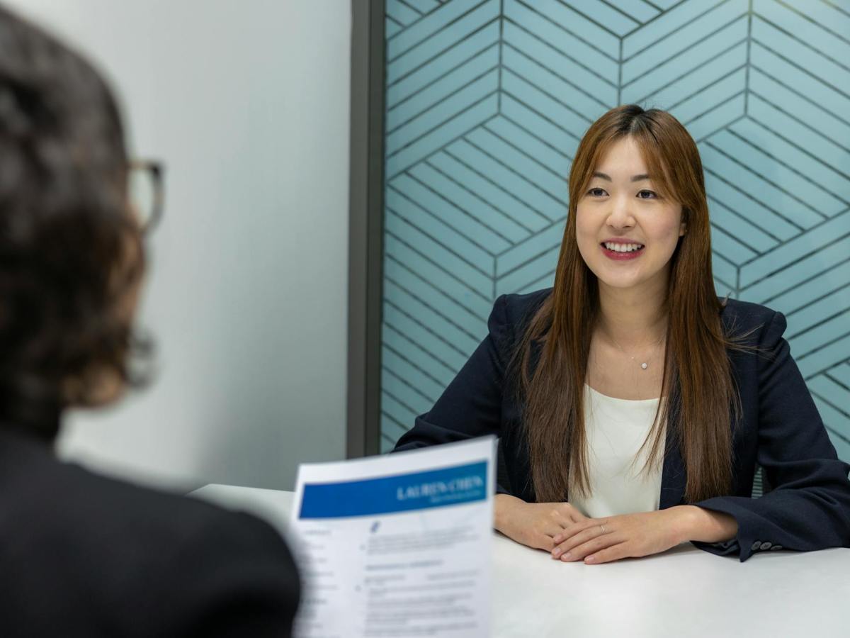 confident beautiful asian woman in suit is smiling during job interview in office environment
