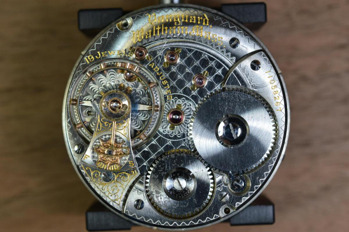 round gray skeleton watch on brown pad