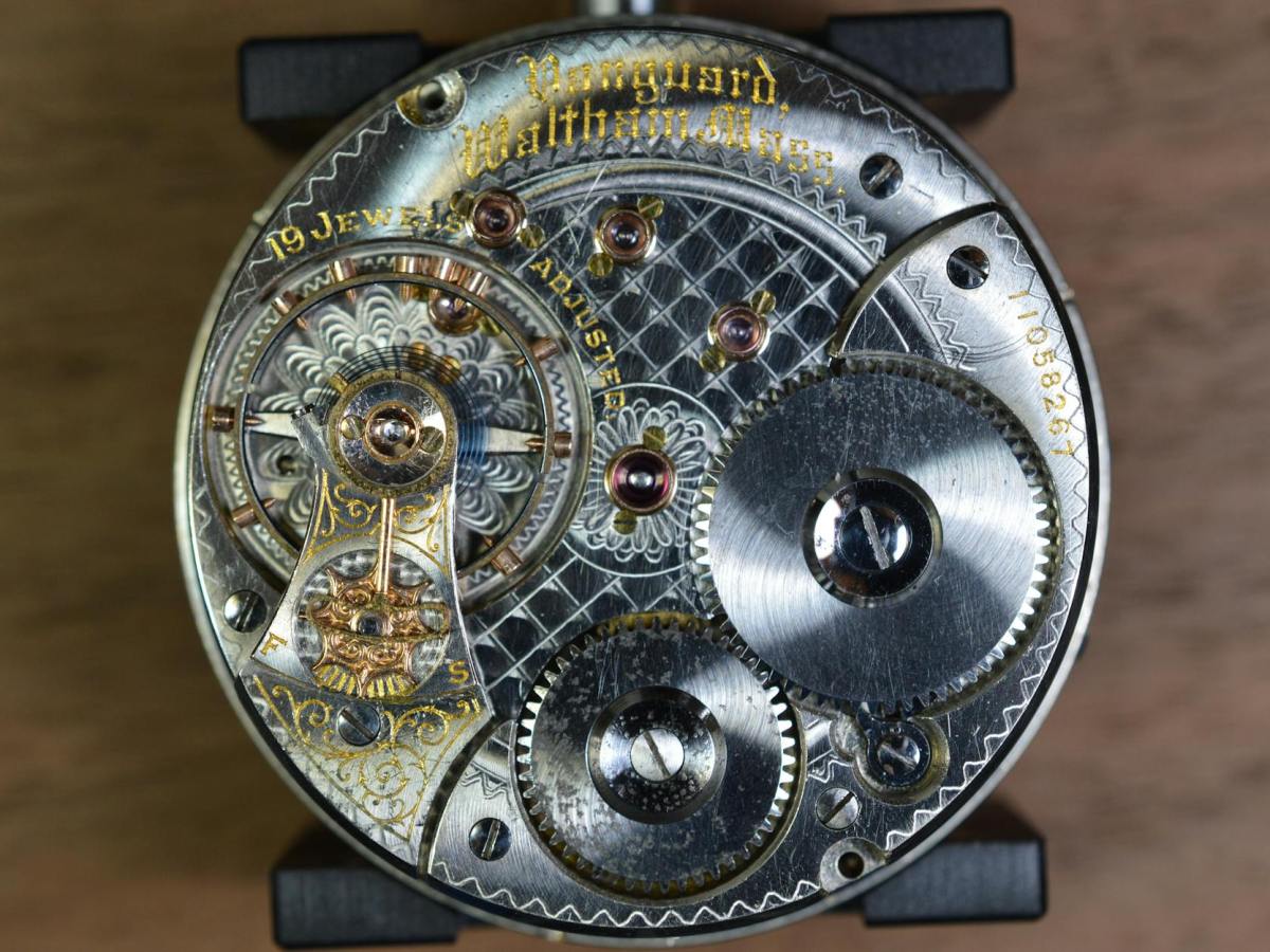 round gray skeleton watch on brown pad