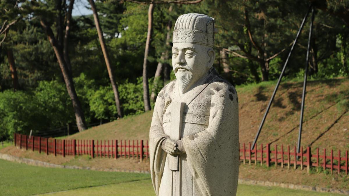 gray concrete statue on green grass field