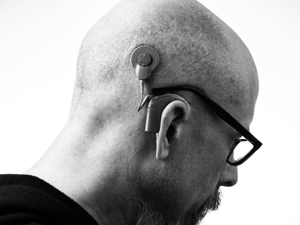 grayscale photo of a man with a hearing aid
