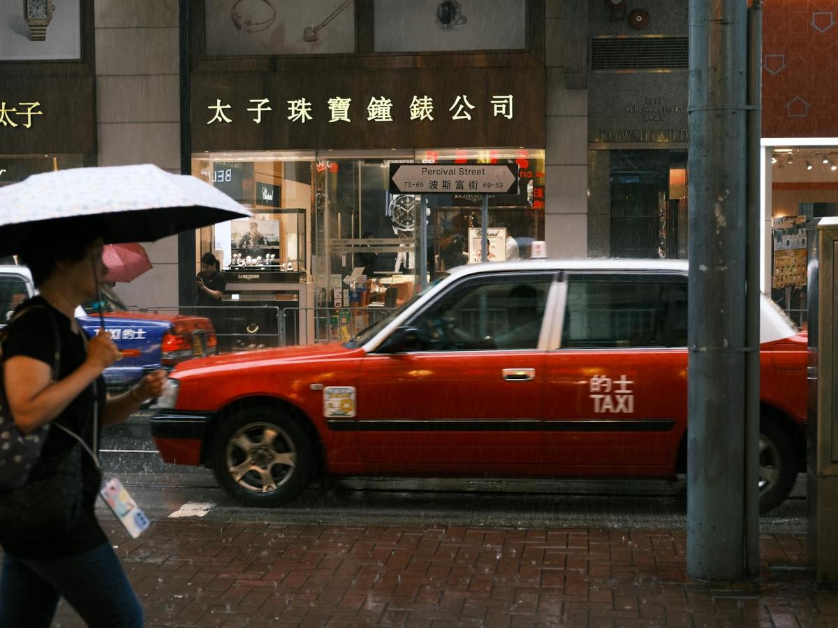 a woman is walking down the street with an umbrella