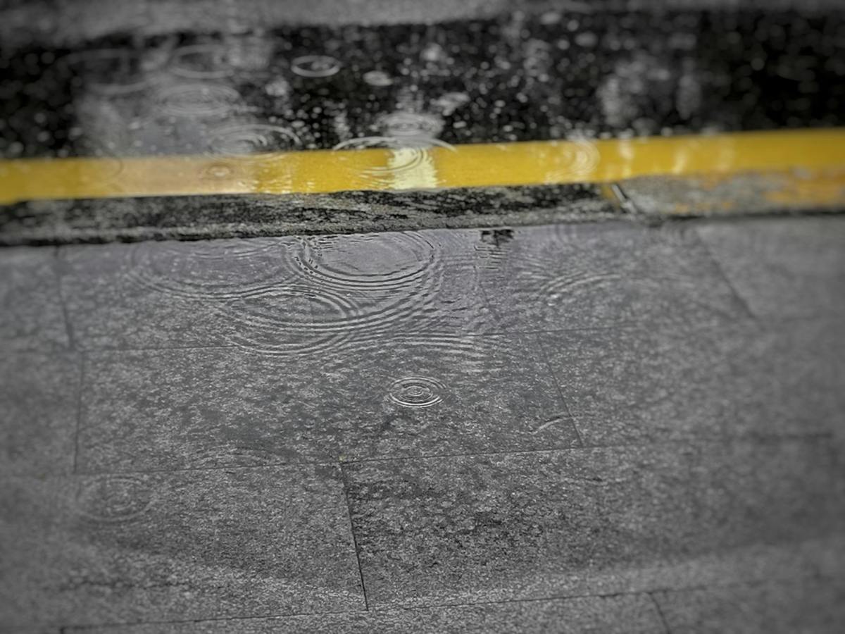 raindrops on wet asphalt with yellow line