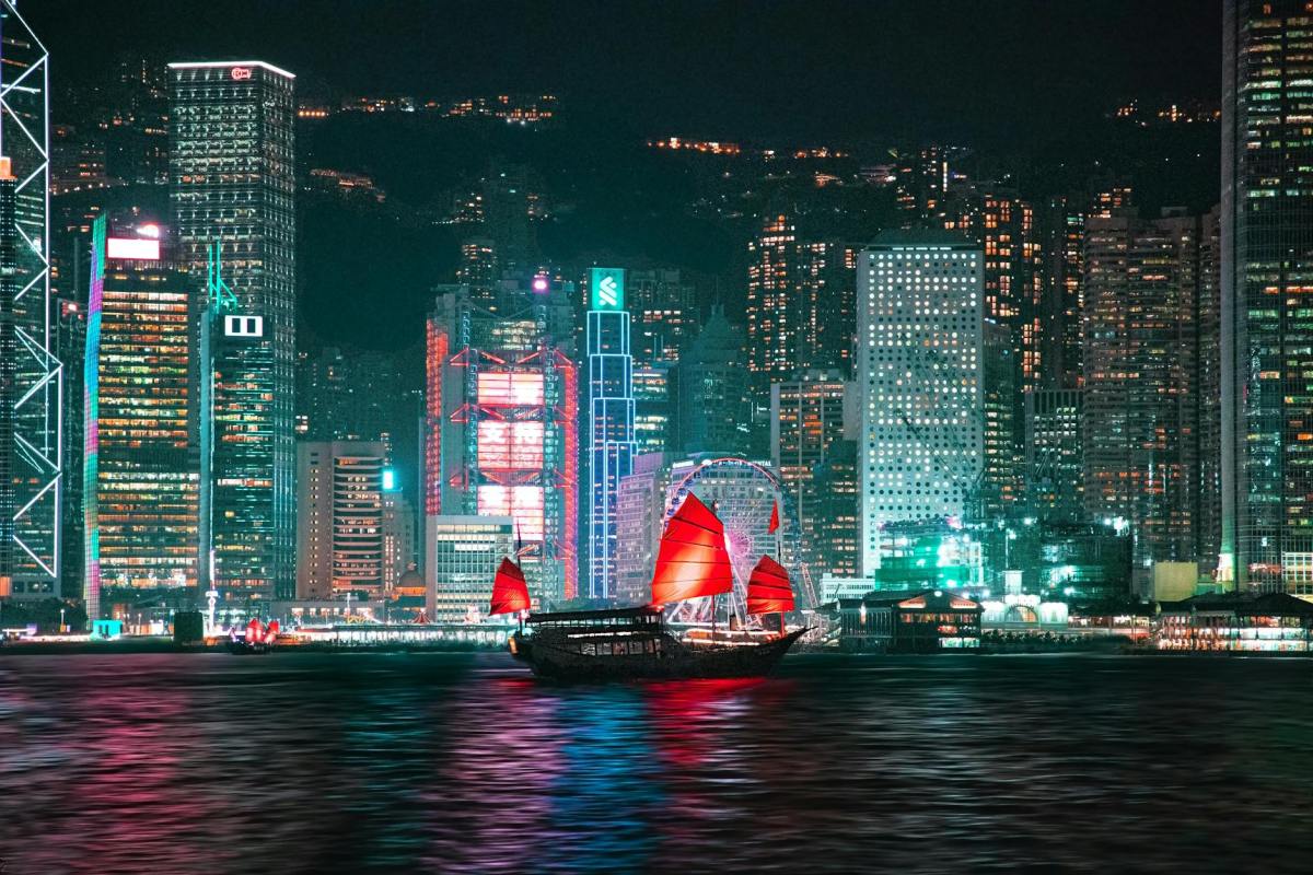 night view of hong kong skyline with traditional junk boat