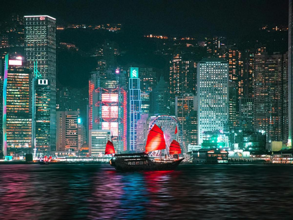 night view of hong kong skyline with traditional junk boat