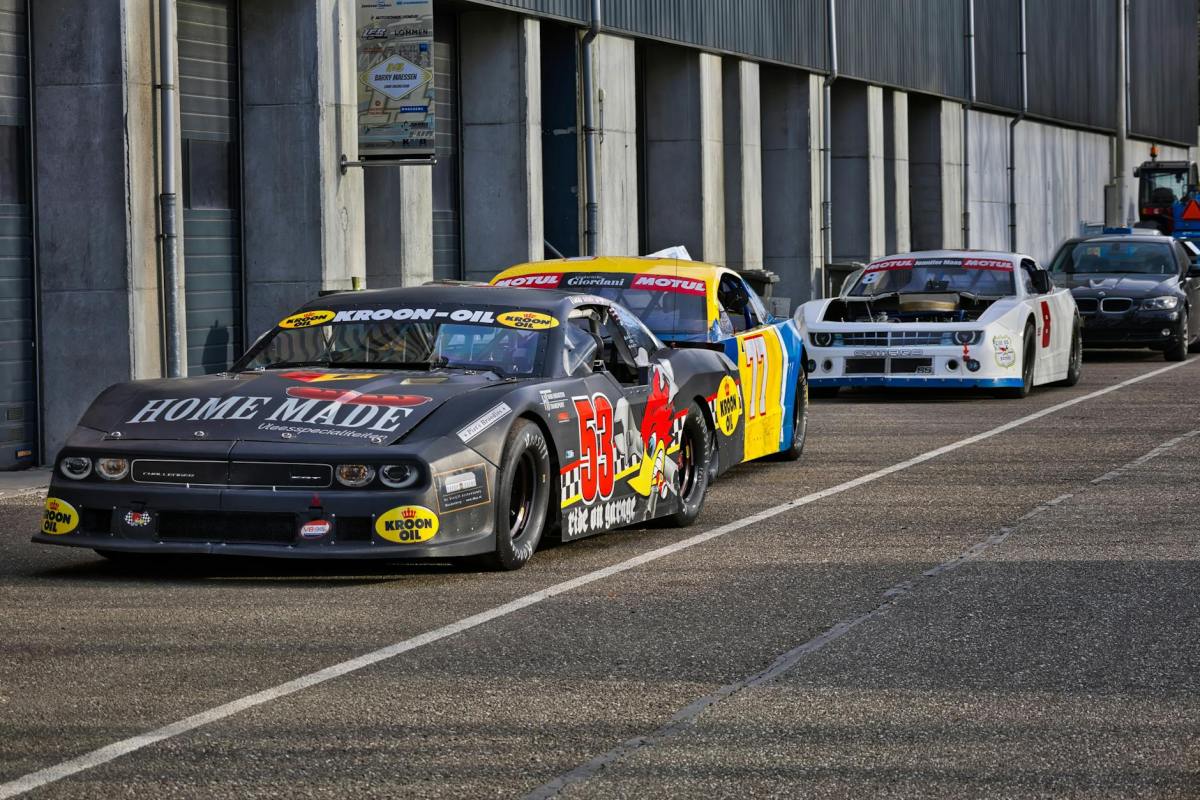 lineup of race cars in a motorsport garage