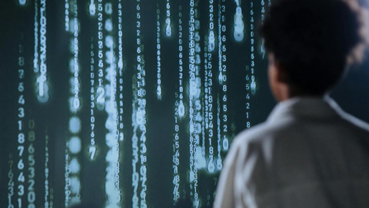 person facing a big screen with numbers