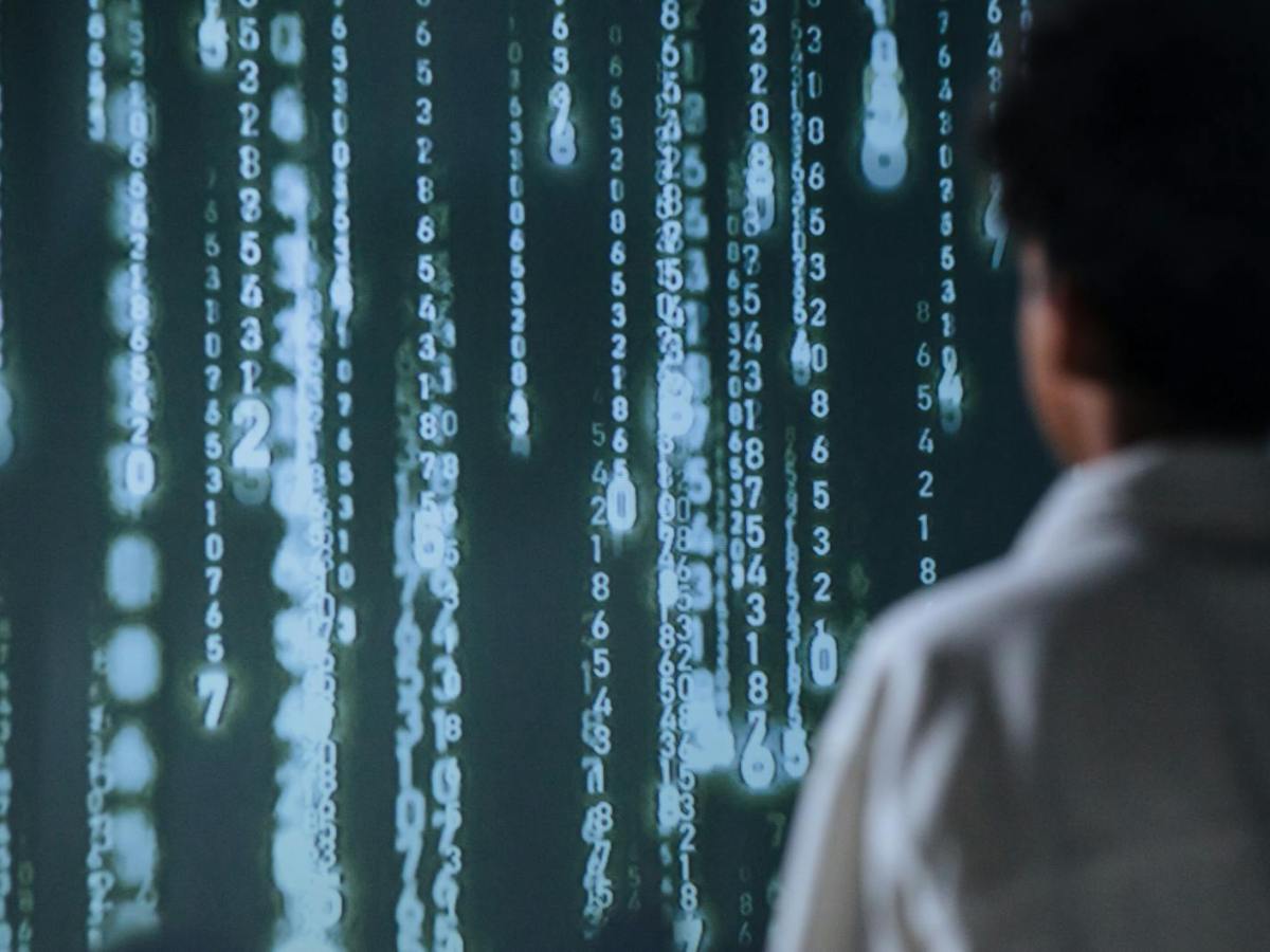 person facing a big screen with numbers