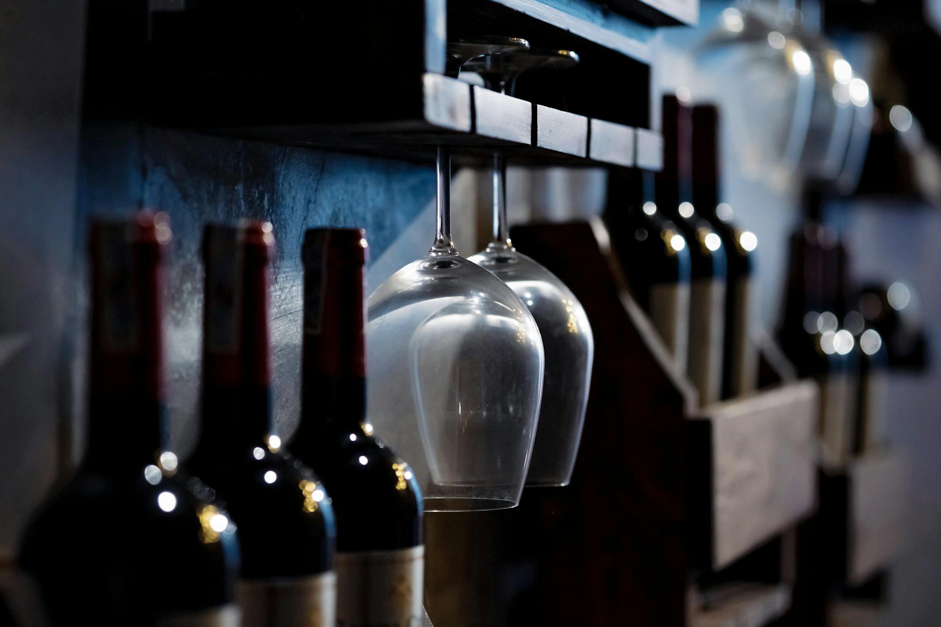 wine glasses and bottles on wooden shelves