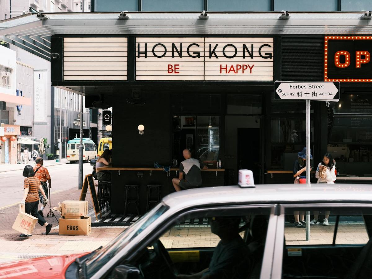 a car drives past a restaurant with a sign that says hong kong