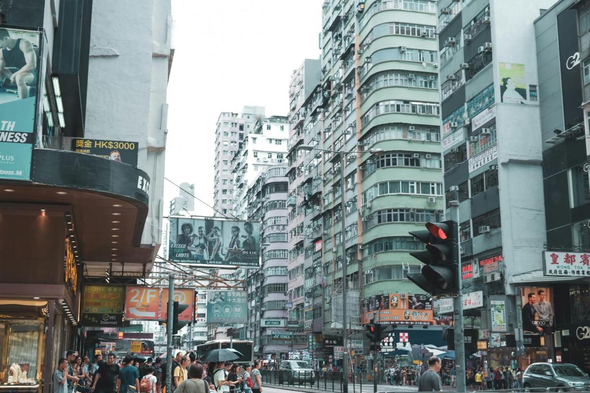 people walking on the street between buildings