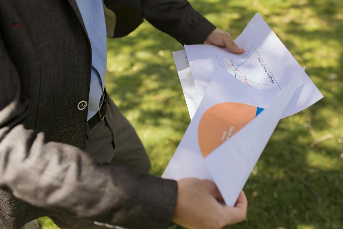 close up shot of a person holding printed papers