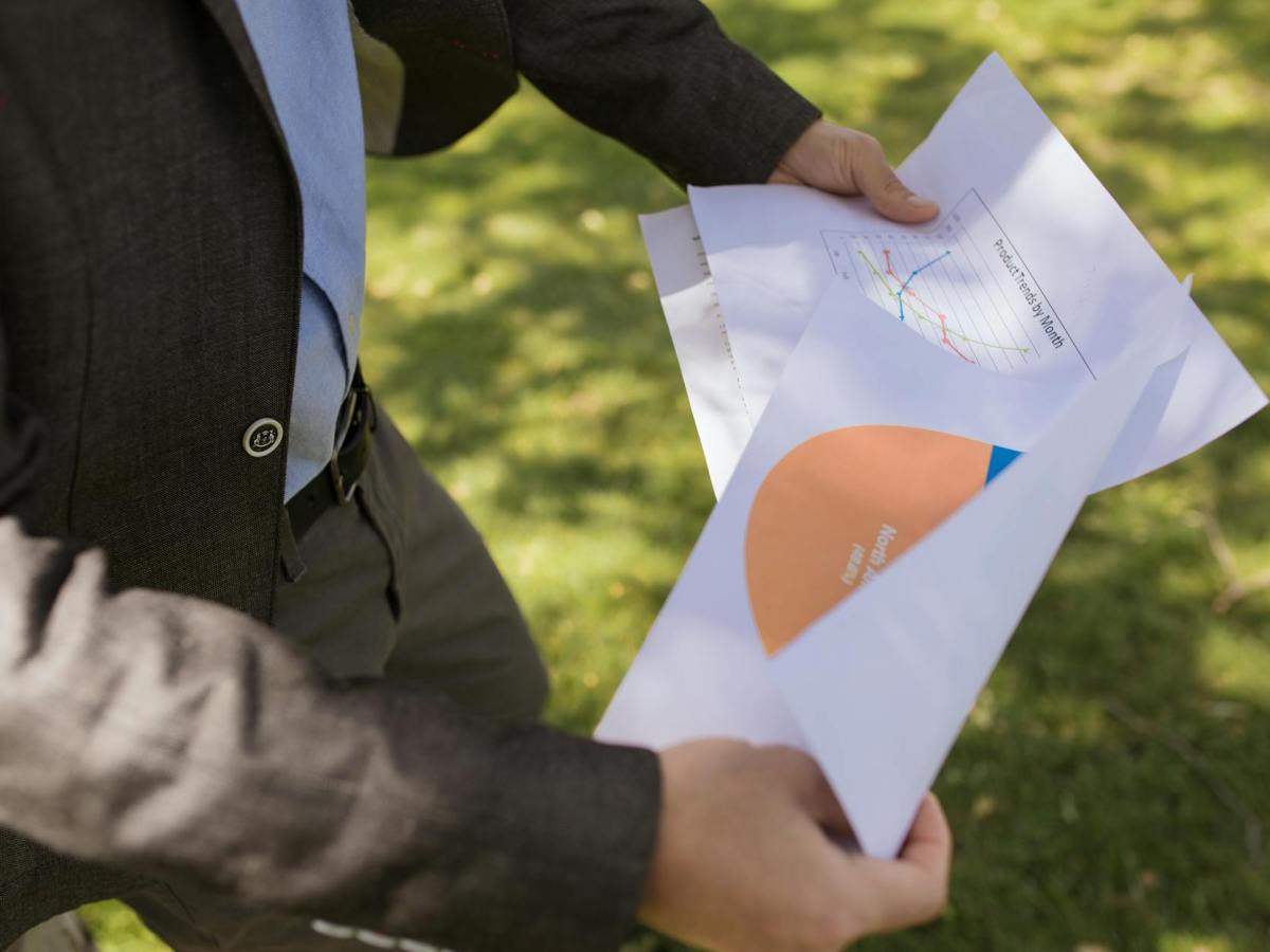 close up shot of a person holding printed papers