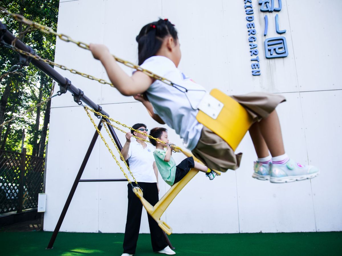 children hanging on a swing