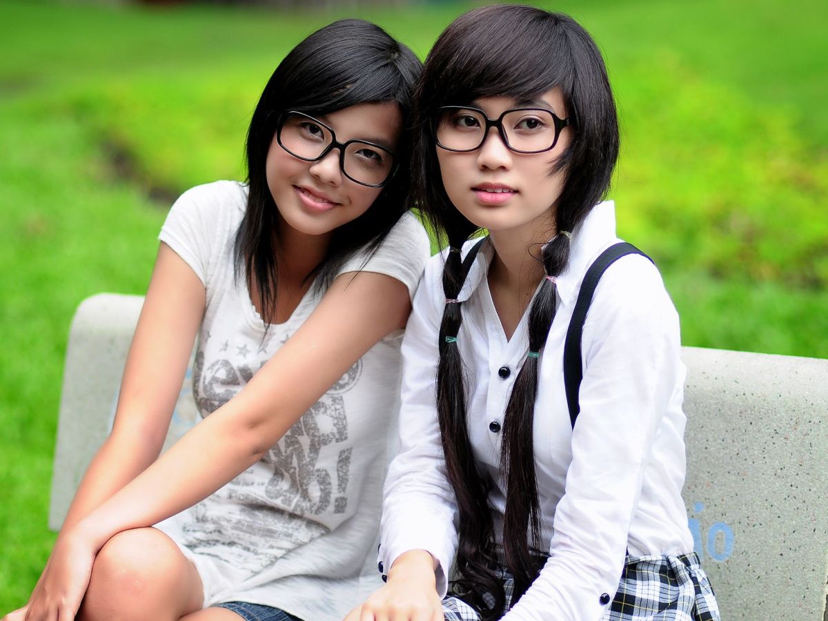 two women sitting on outdoor bench
