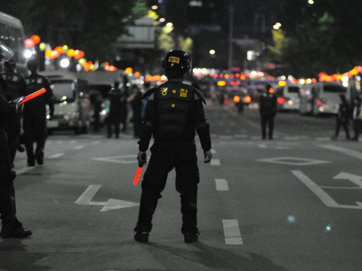 police standing on gray asphalt during nighttime