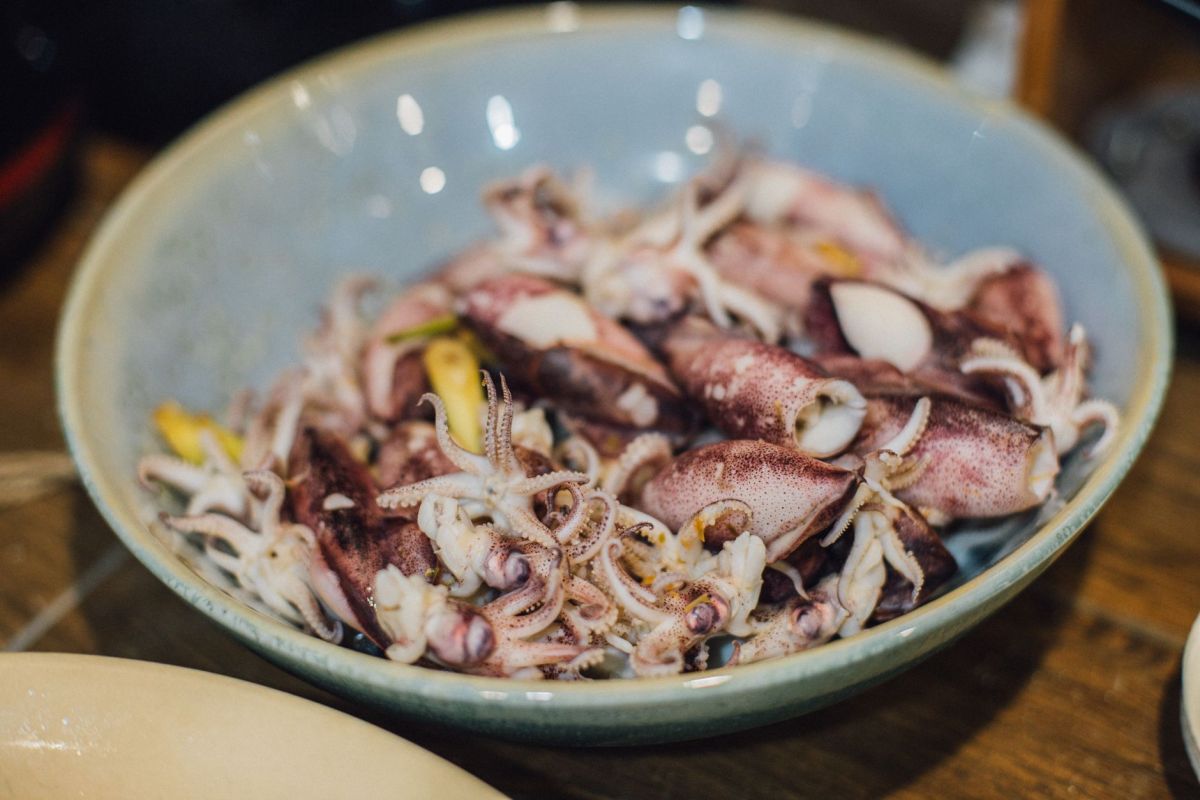 fresh squid in ceramic bowl close up