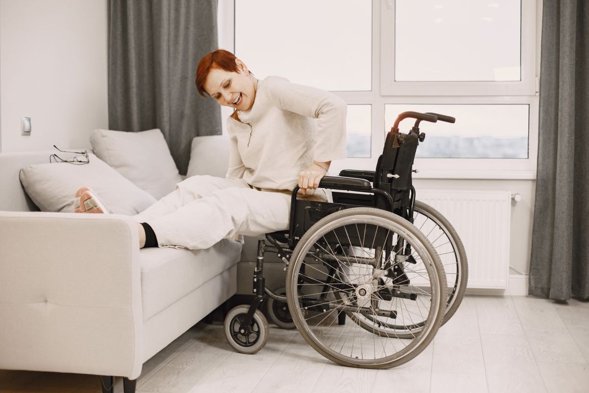 woman moving from wheelchair to bed