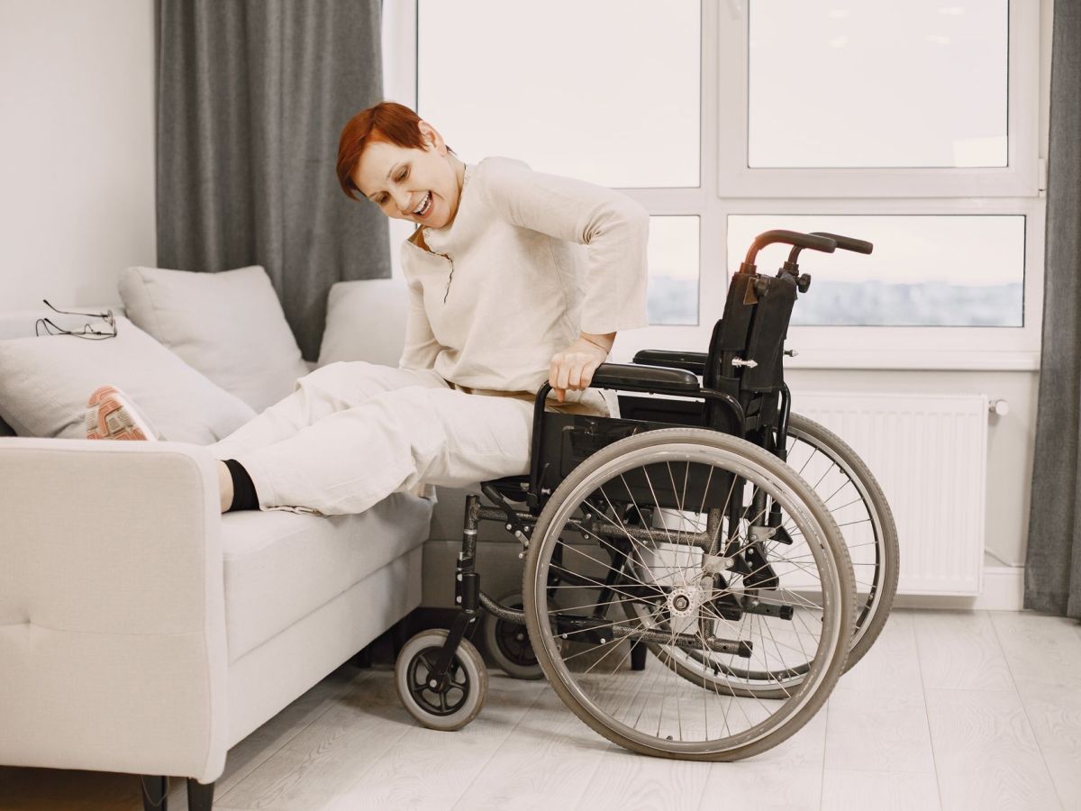 woman moving from wheelchair to bed