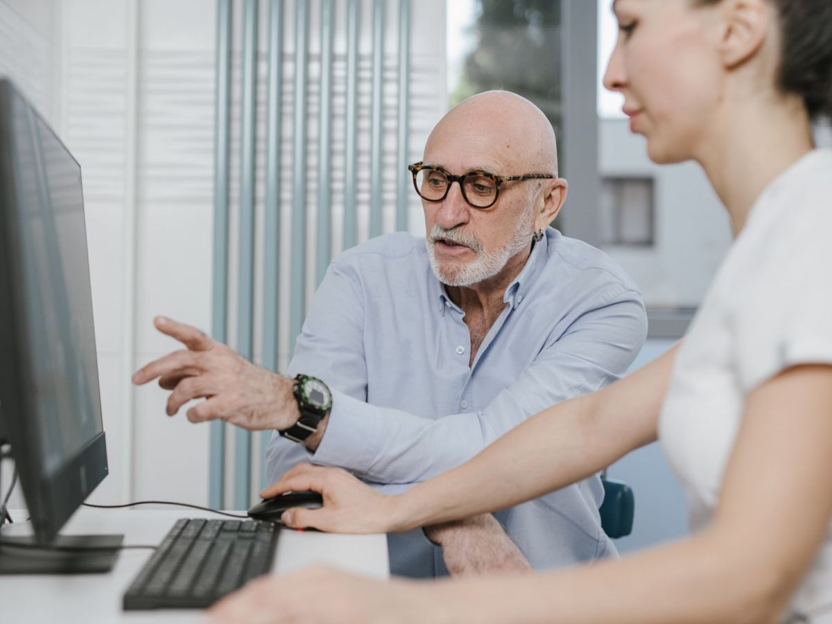 elderly man wearing eyeglasses pointing on the screen