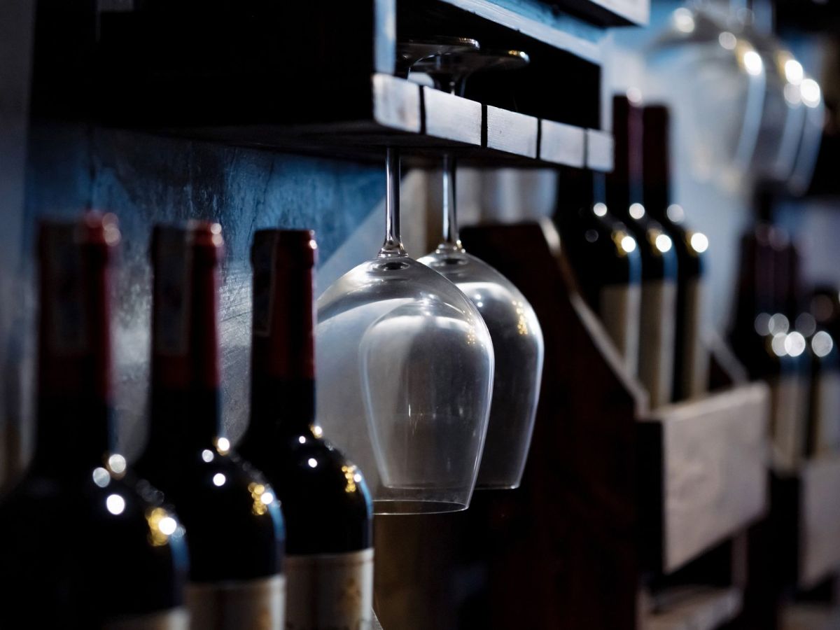 wine glasses and bottles on wooden shelves
