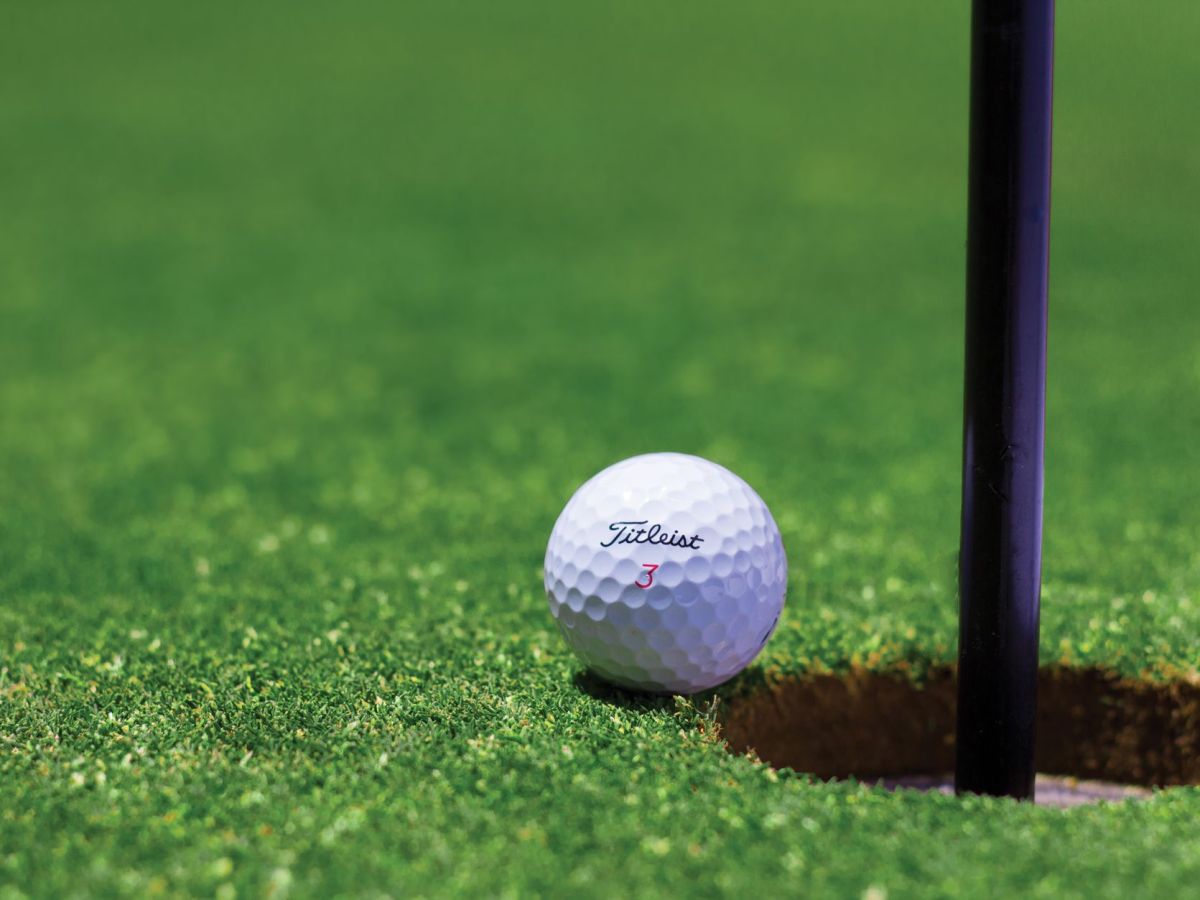 titrist golf ball near golf hole